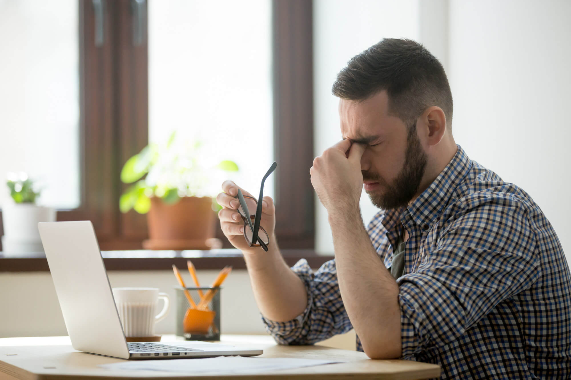 Top 8 Common Affiliate Marketing Mistakes stressed male massaging nose bridge suffering from headache - Top 8 Common Affiliate Marketing Mistakes